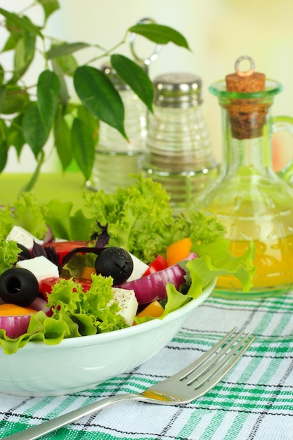Salade grecque sur plaque sur table sur fond clair