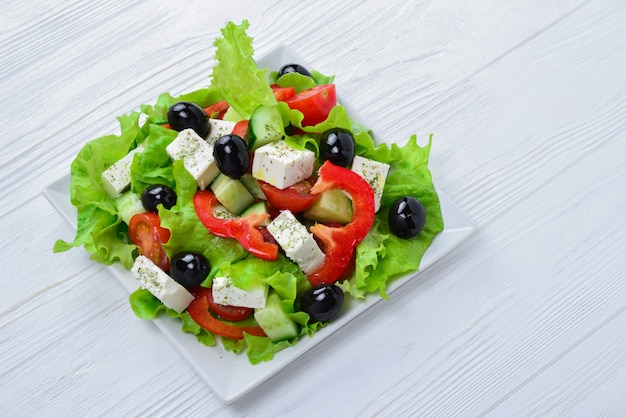 Salade grecque sur une table en bois blanc. Espace pour le texte ou le design.