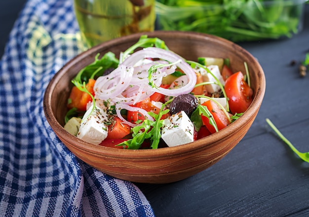 Salade grecque avec tomates fraîches, concombre, oignon rouge, basilic, fromage feta, olives noires et herbes italiennes