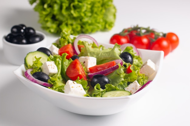 Salade grecque avec tomates fraîches, concombre, olives, fromage feta et oignon rouge. Alimentation saine et diététique