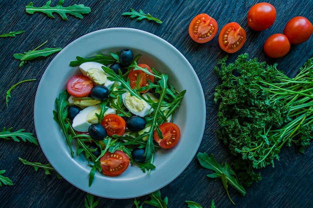 Salade grecque avec tomates fraîches, roquette, œufs et olives