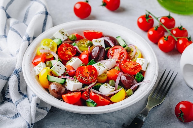 Salade grecque traditionnelle avec concombre frais laitue tomate câpres oignon rouge fromage feta et olives