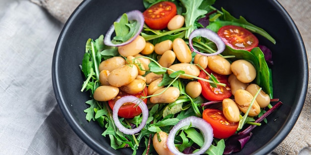 Salade de haricots blancs feuilles de tomate mélange de laitue pétales portion fraîche repas sain régime alimentaire collation