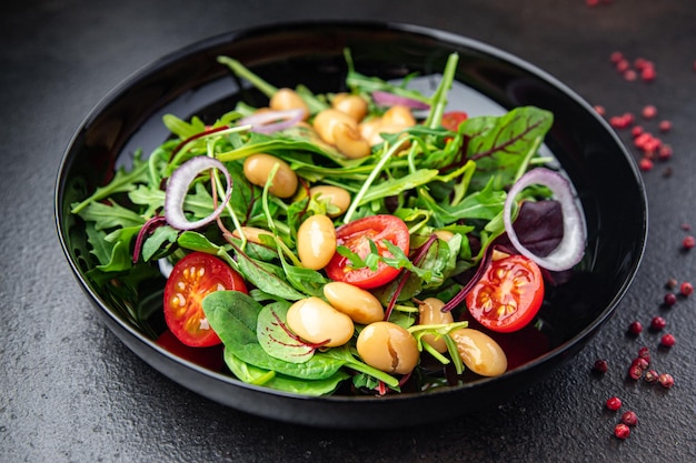 Salade de haricots blancs feuilles de tomate mélange de laitue pétales portion fraîche repas sain régime alimentaire collation