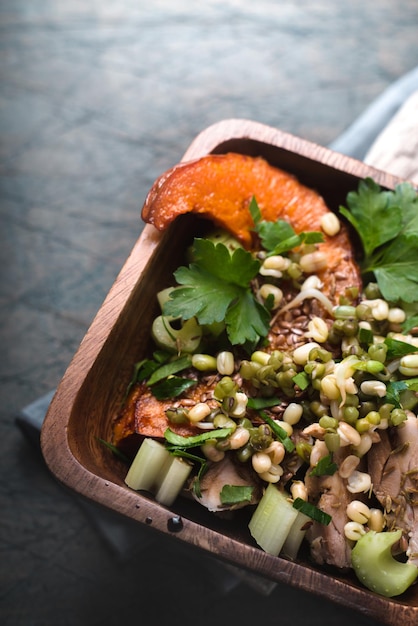 Salade de haricots de potiron au poulet dans un bol en bois