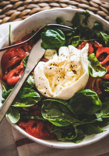 Salade italienne au fromage Buratta en gros plan bol blanc