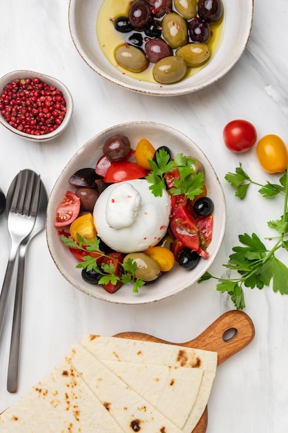 Salade italienne au fromage burrata avec tomates, olives et huile d'olive