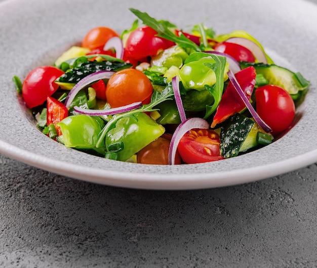 Salade de jardin biologique fraîche sur une assiette grise