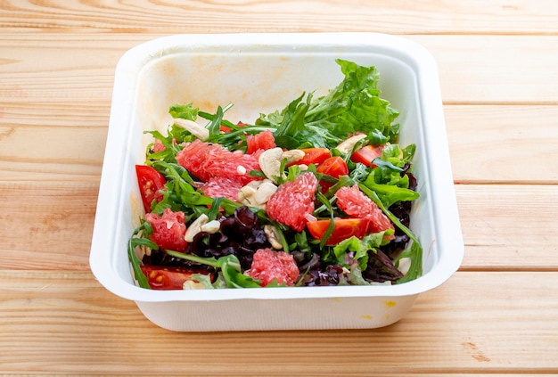 Photo salade juteuse avec pamplemousse et roguela régime alimentaire sain nourriture à emporter sur un fond en bois