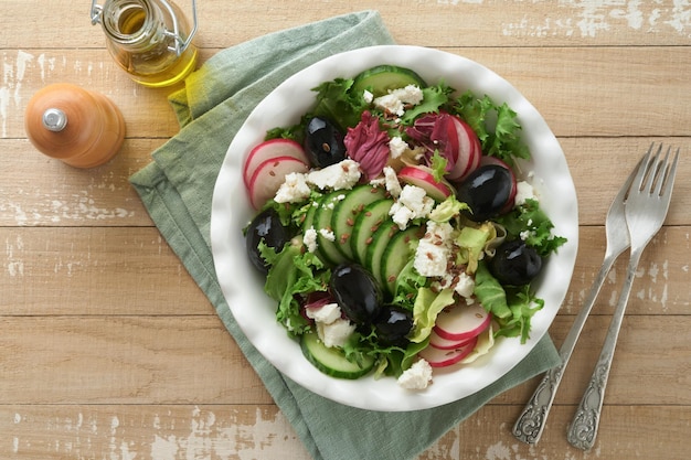 Salade de laitue salade de radis de concombre avec fromage cottage et graines de lin salade d'huile d'olive sur fond de bois ancien Alimentation saine Menu diététique et alimentation équilibrée Vue de dessus