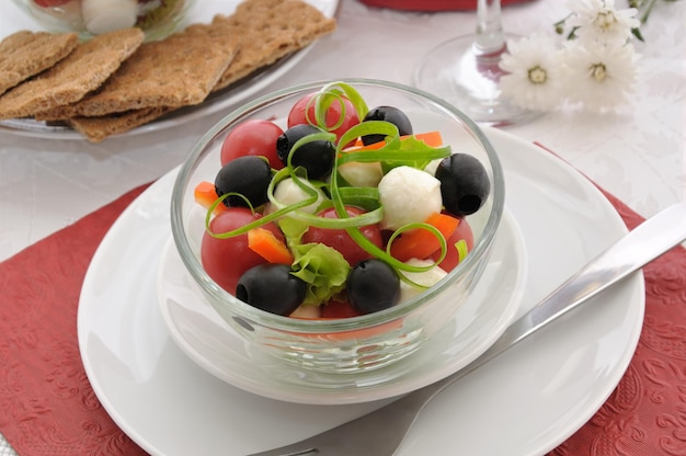 Salade de laitue tomates cerises olives et mozzarella au poivre