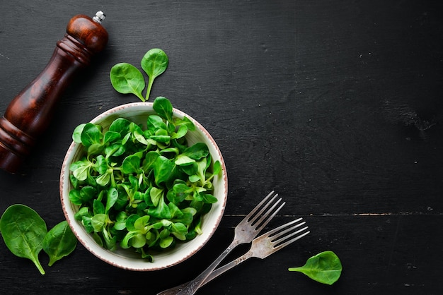 Salade de laitue verte fraîche dans une assiette sur un fond en bois Vue de dessus Espace libre pour votre texte Mise à plat