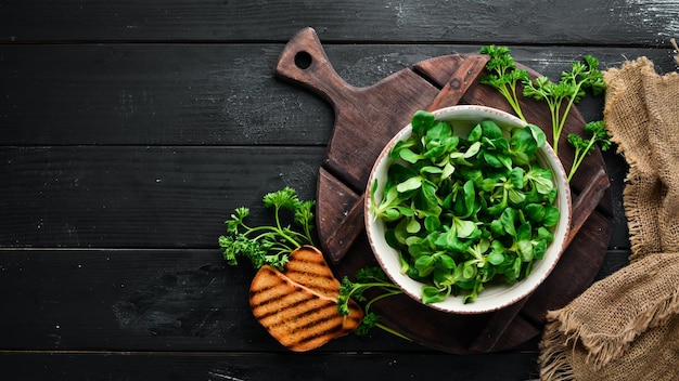 Salade de laitue verte fraîche dans une assiette sur un fond en bois Vue de dessus Espace libre pour votre texte Mise à plat