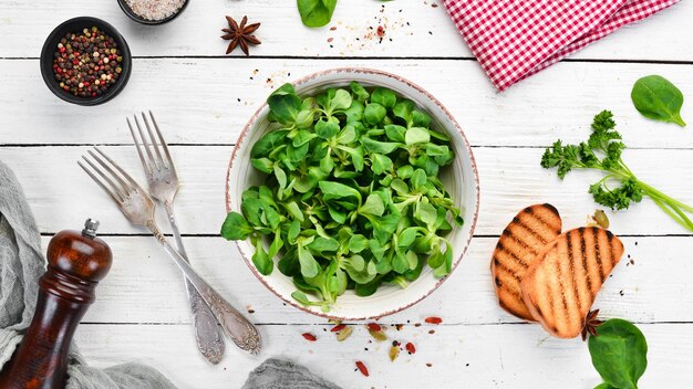 Salade de laitue verte fraîche dans une assiette sur un fond en bois Vue de dessus Espace libre pour votre texte Mise à plat