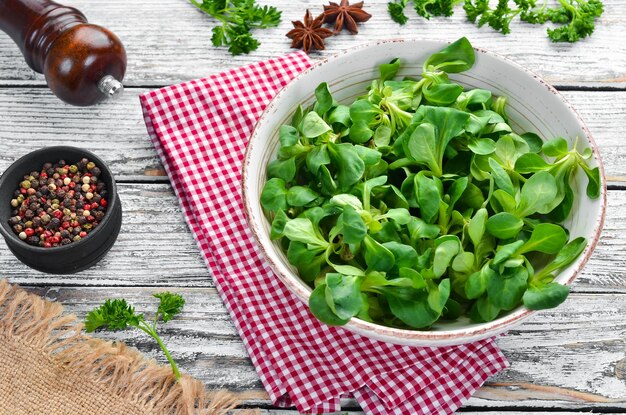 Salade de laitue verte fraîche dans une assiette sur un fond en bois Vue de dessus Espace libre pour votre texte Mise à plat