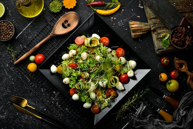 Salade de légumes au fromage mozzarella Sur une plaque noire Vue de dessus Nourriture Style rustique