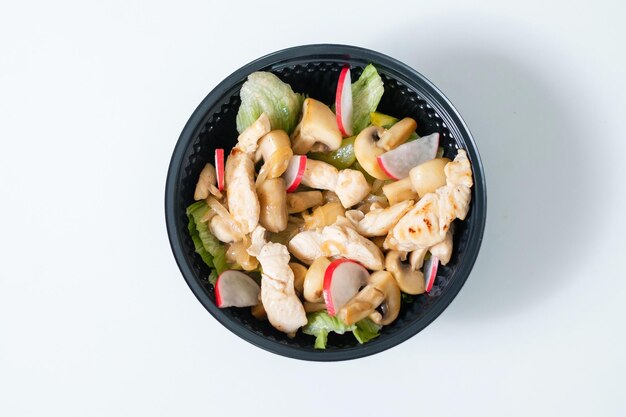 Salade de légumes au poulet dans un bol jetable