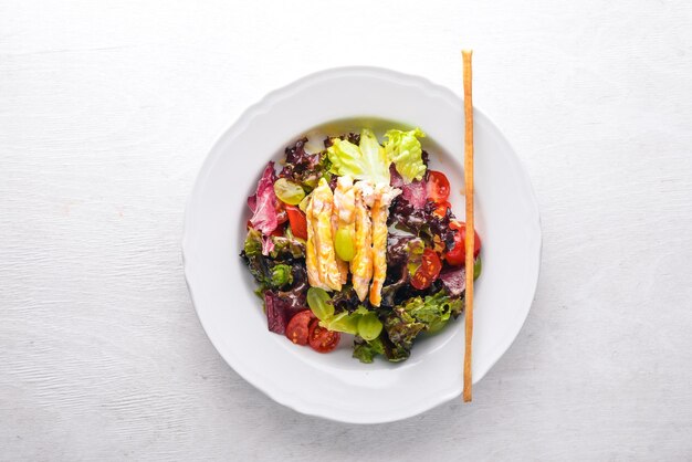 Salade de légumes au poulet et sauce à la mangue sur fond de bois Vue de dessus Espace libre pour le texte