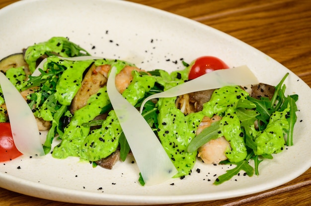 Photo salade de légumes aux aubergines frites sur plaque blanche sur fond de bois