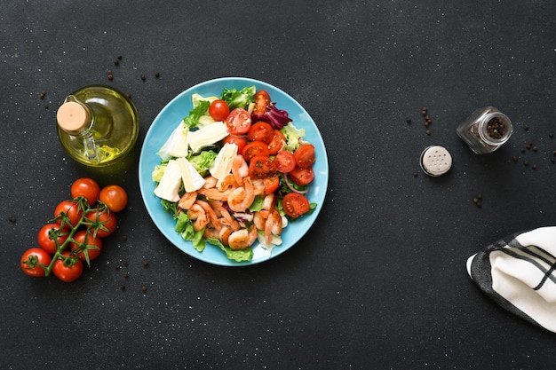 Photo salade de légumes aux crevettes et fromage dans une vue de dessus de plaque bleue