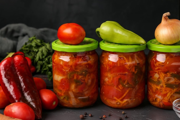 Salade de légumes en bocaux pour l'hiver de tomates carottes oignons et poivrons disposition horizontale