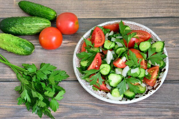 salade de légumes avec concombre, tomates et persil sur assiette, gros plan