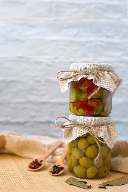 Salade de légumes en conserve dans un pot se dresse sur un pot avec des olives marinées