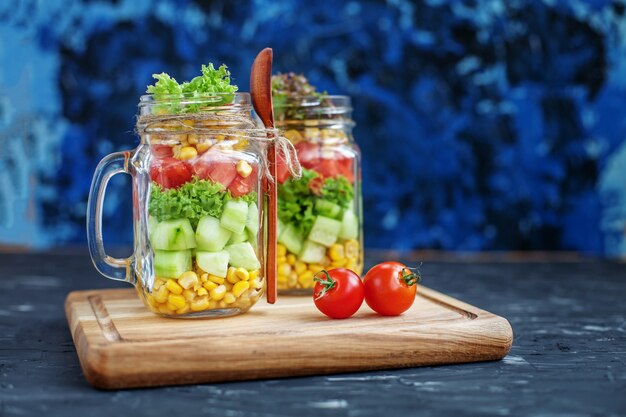 Salade de légumes dans un bocal en verre et une cuillère.