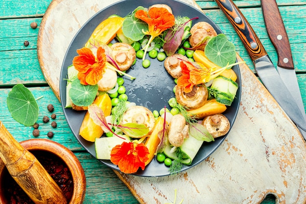 Salade de légumes d'été décorée de fleurs de capucine. Nourriture végétarienne saine