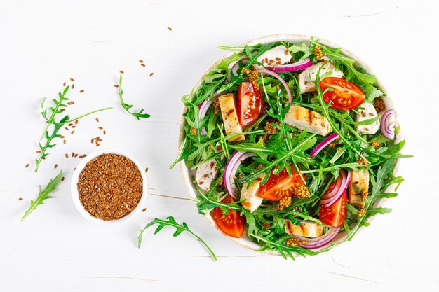 Salade de légumes frais avec filet de poulet grillé, tomate de poitrine et roquette vue de dessus