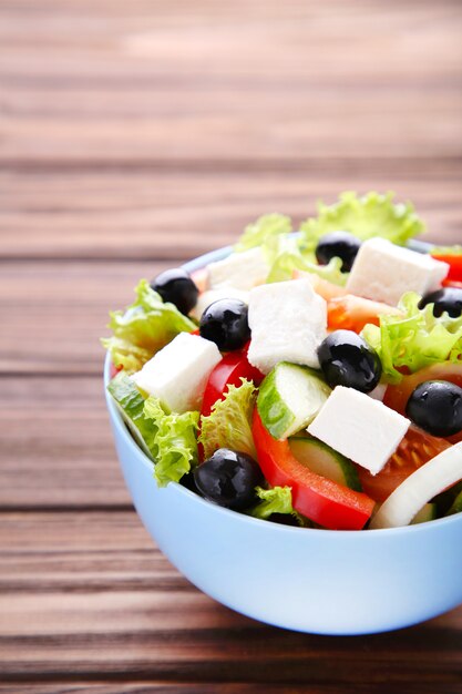 Salade de légumes frais sur un fond en bois marron