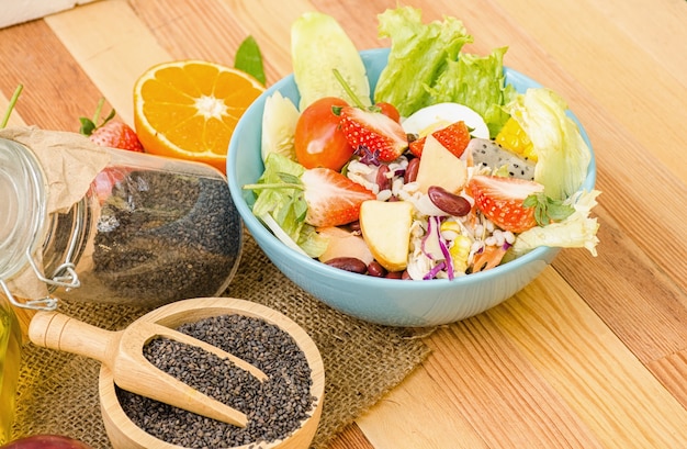 Salade de légumes frais et de fruits sur la table en bois