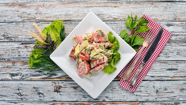 Salade de légumes frais avec pâte de noix Cuisine géorgienne Sur le vieux fond en bois Espace libre pour le texte Vue de dessus