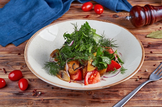 Salade de légumes frais avec pommes de terre au four et champignons, en bois