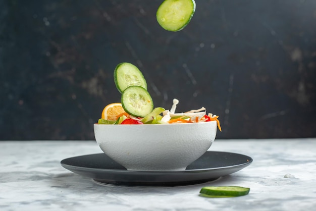 Salade de légumes frais vue de face avec des concombres sur l'obscurité