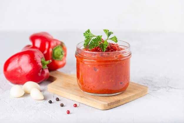 Salade de légumes lecho de tomates poivrons oignons ail et épices dans un bocal en verre