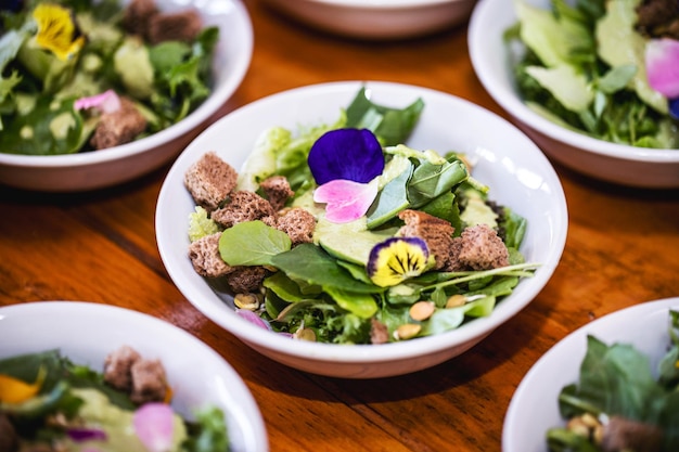 Salade de légumes légumes et fleurs plusieurs saladiers avec pétales de fleurs de roquette toast végétalien