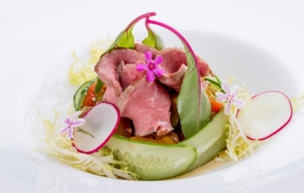 Salade de légumes et rôti de boeuf sur fond blanc