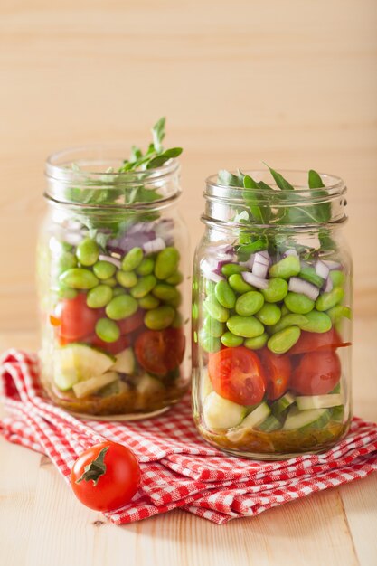 Salade de légumes sains en pot Mason: tomate, concombre, soja, oignon