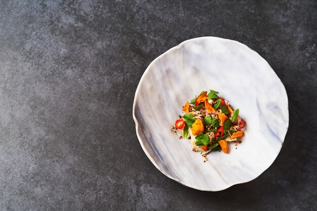 Salade de légumes végétarienne avec filet de poisson frais.