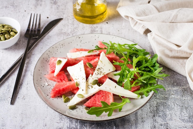 Salade maison de melon d'eau au fromage feta et de roquette sur une assiette Régime biologique