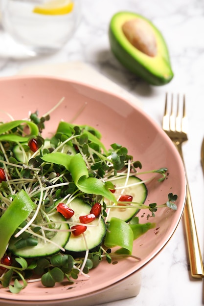 Salade de micro-verts biologiques frais dans un bol sur un gros plan de tableau blanc