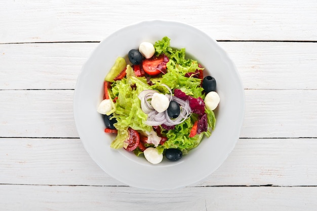 Salade de mozzarella et légumes frais Sur un fond en bois blanc Vue de dessus Copier l'espace pour votre texte