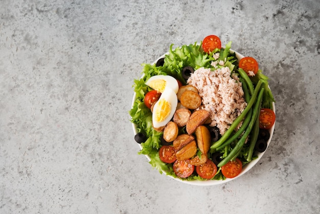 Salade niçoise au thon, haricots, légumes et pommes de terre, vue de dessus, espace copie