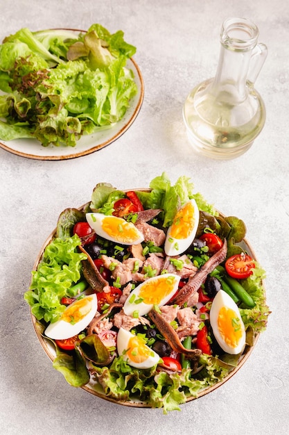 Photo salade niçoise au thon oeufs haricots verts tomates olives laitue et anchois