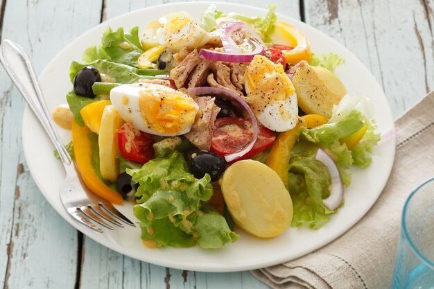 Photo salade niçoise sur fond de bois