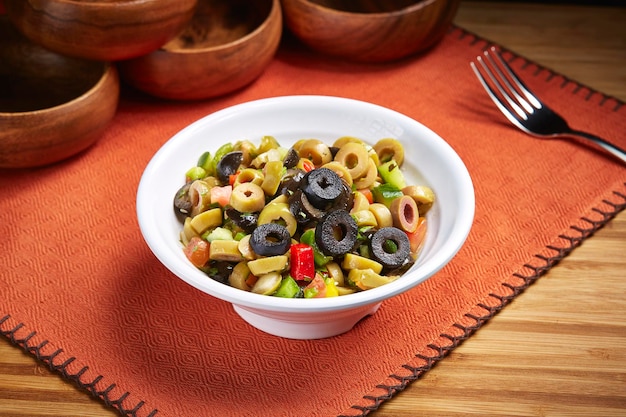 Salade d'olives de santé fraîche avec tomate concombre servie dans un plat isolé sur la vue latérale de la table de la nourriture du moyen-orient