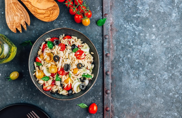 Salade d'orzo méditerranéenne aux olives noires, basilic, oignon rouge, tomate et concombre