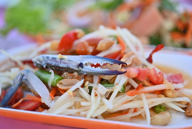 Salade de papaye aux fruits de mer dans un plat isolé sur fond blanc Image avec un tracé de détourage