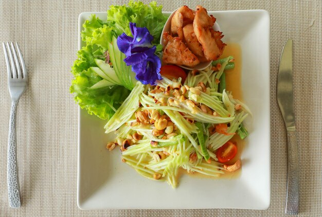 Salade de papaye thaïlandaise chaude et épicée mélangée à une variété de légumes